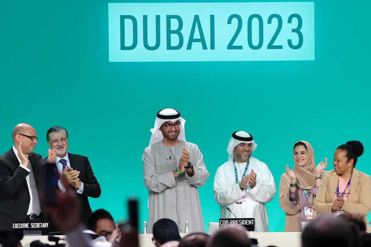 El presidente de la COP28, Sultan Ahmed Al Jaber (C), aplaude entre otros funcionarios antes de una sesión plenaria durante la cumbre climática de las Naciones Unidas en Dubai el 13 de diciembre de 2023. (Foto de Giuseppe CACACE / AFP)