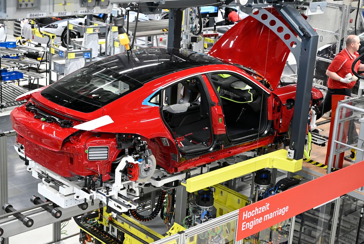 Un Porsche Taycan, el primer automóvil totalmente eléctrico del fabricante alemán de automóviles de lujo Porsche AG, se encuentra en la línea de montaje de la planta de la compañía en Stuttgart, al suroeste de Alemania, durante el proceso de ensamblaje, donde el chasis y el motor se unen a la carrocería. (Foto de THOMAS KIENZLE / AFP)