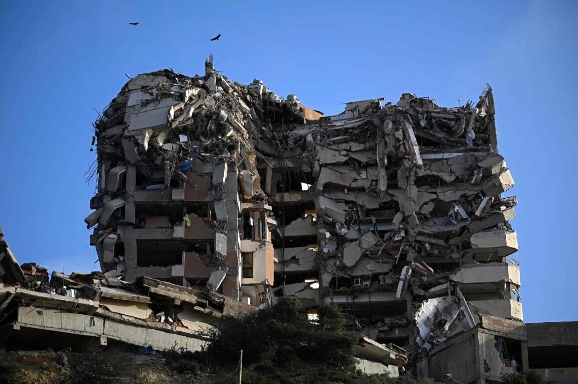 Edificio de varias plantas gravemente dañado, con los pisos superiores derrumbados, en el sector Playa Verde de Catia La Mar, estado La Guaira, Venezuela. (Foto de Federico PARRA / AFP).