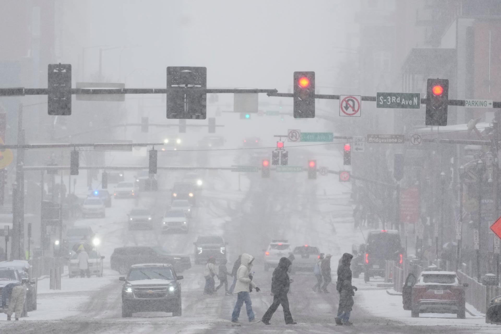 Peatones cruzan la calle Broadway durante una tormenta invernal el sábado 24 de enero de 2026 en Nashville, Tennessee. (Foto AP/George Walker IV)