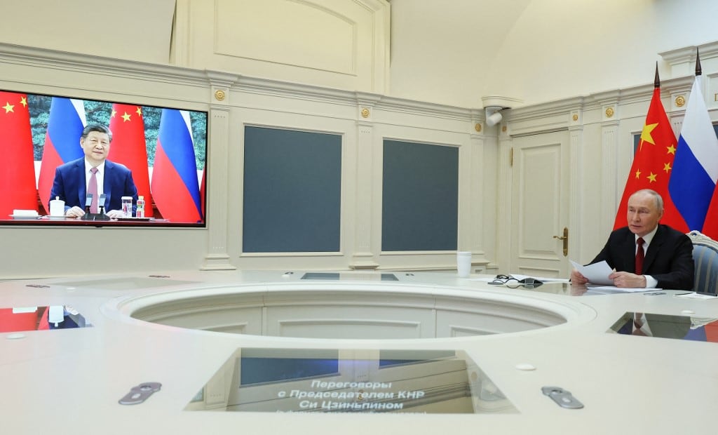 In this pool photograph distributed by the Russian state agency Sputnik, Russia's President Vladimir Putin holds a video call with Chinese President Xi Jinping in Moscow on February 4, 2026. (Photo by Vyacheslav PROKOFYEV / POOL / AFP)