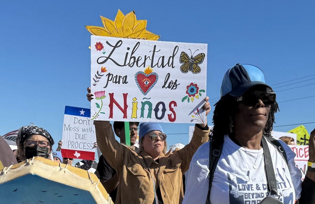 Un manifestante sostiene un cartel que exige la libertad de los niños durante una manifestación y vigilia frente al Centro Residencial Familiar del Sur de Texas en Dilley, Texas, el 28 de enero de 2026. (Foto de Moisès VILA / AFP)