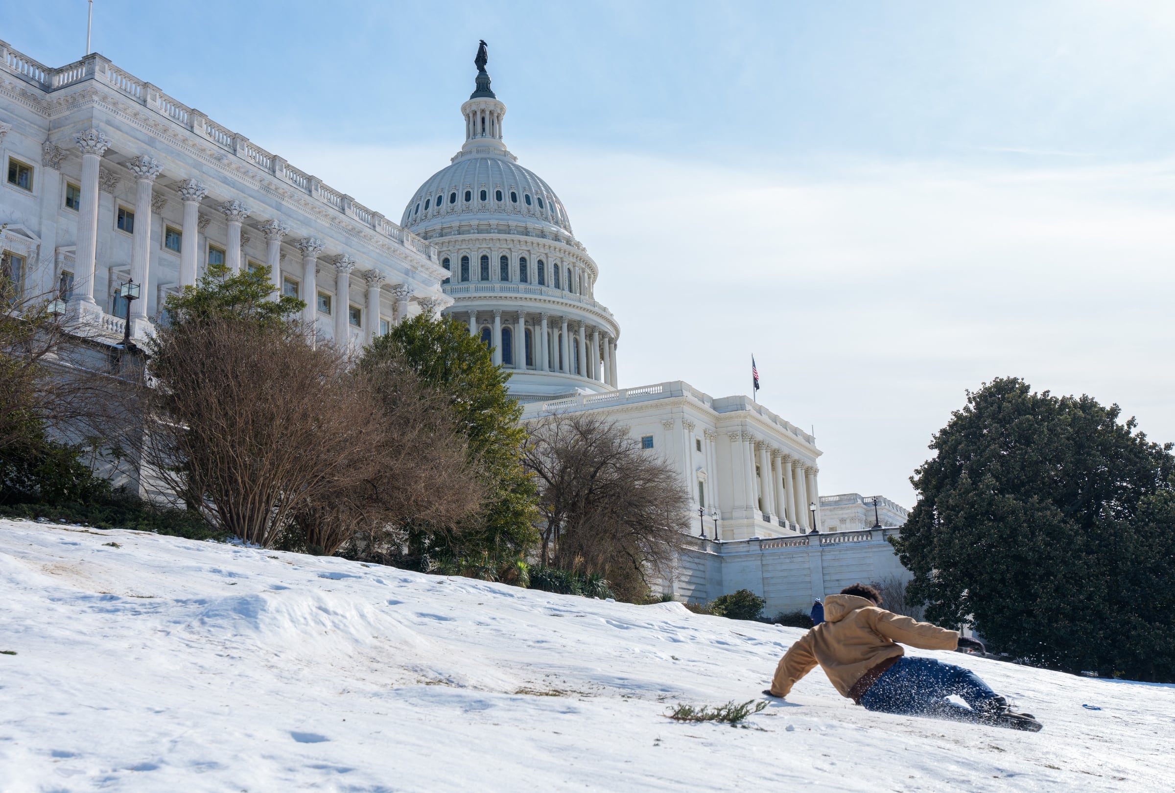 Una persona se desliza por el césped helado del West Lawn, en el complejo del Capitolio de los Estados Unidos, en Washington D. C., el 31 de enero del 2026 (Foto: Aaron Schwartz / AFP)