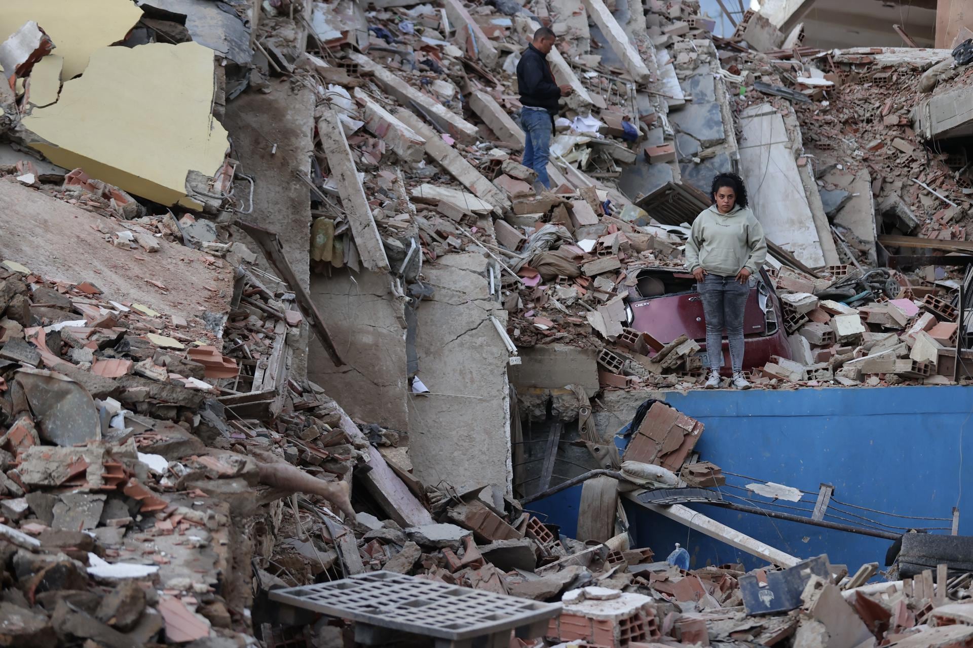 Residentes caminan entre los escombros de edificios derrumbados por los terremotos en la localidad de Catia La Mar, en el estado costero de La Guaira, Venezuela. (EFE/ Ronald Pena R.).
