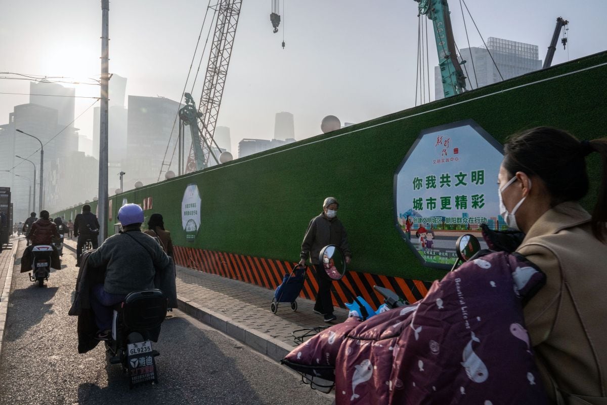 Ciudadanos chinos pasan por una obra en construcción en Pekín, China, el lunes 30 de octubre de 2023. Foto: Bloomberg