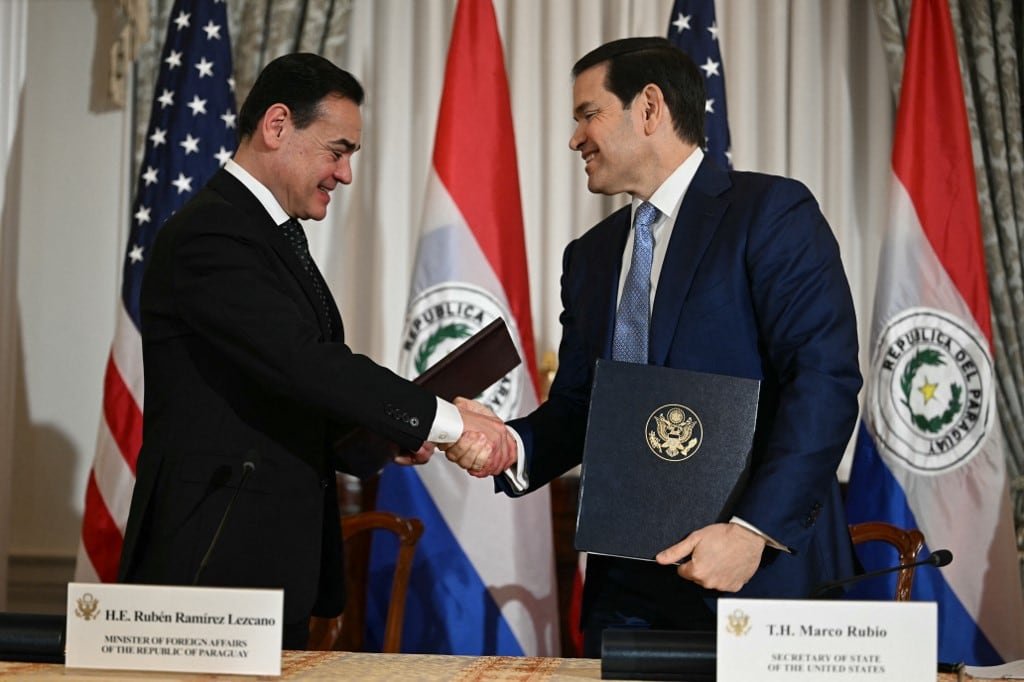 El secretario de Estado de Estados Unidos, Marco Rubio (derecha), y el ministro de Relaciones Exteriores de Paraguay, Rubén Ramírez Lezcano, se dan la mano mientras intercambian documentos en el Departamento de Estado en Washington, D.C., el 15 de diciembre de 2025. (Foto de Jim WATSON / AFP)