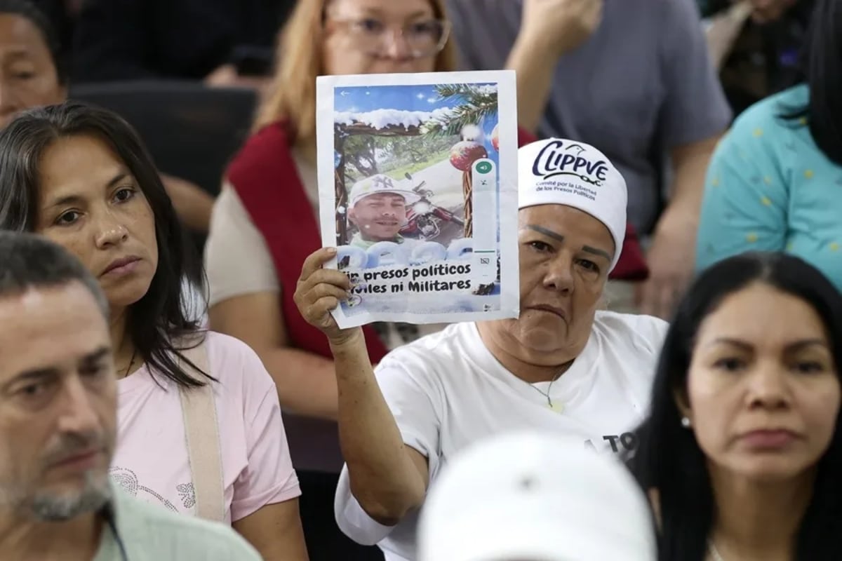 Una mujer sostienen un cartel con la imagen de un preso político, durante una rueda de prensa en Caracas (Venezuela). (Foto: EFE/ Ronald Peña R)