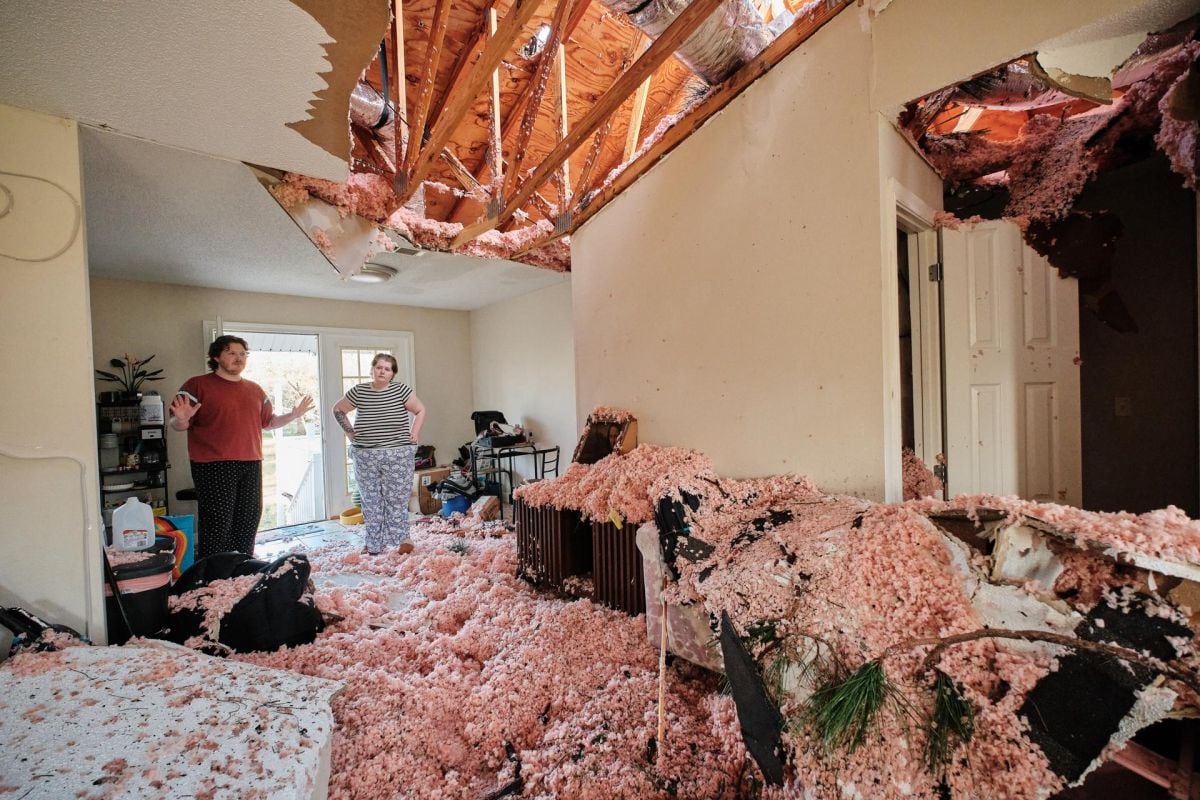 Dos personas inspeccionan los daños en su vivienda, donde un árbol atravesó el tejado tras tocar tierra el huracán Isaías en Milton, Florida, el 10 de octubre de 2026 (Foto: EFE/EPA/Dan Anderson)
