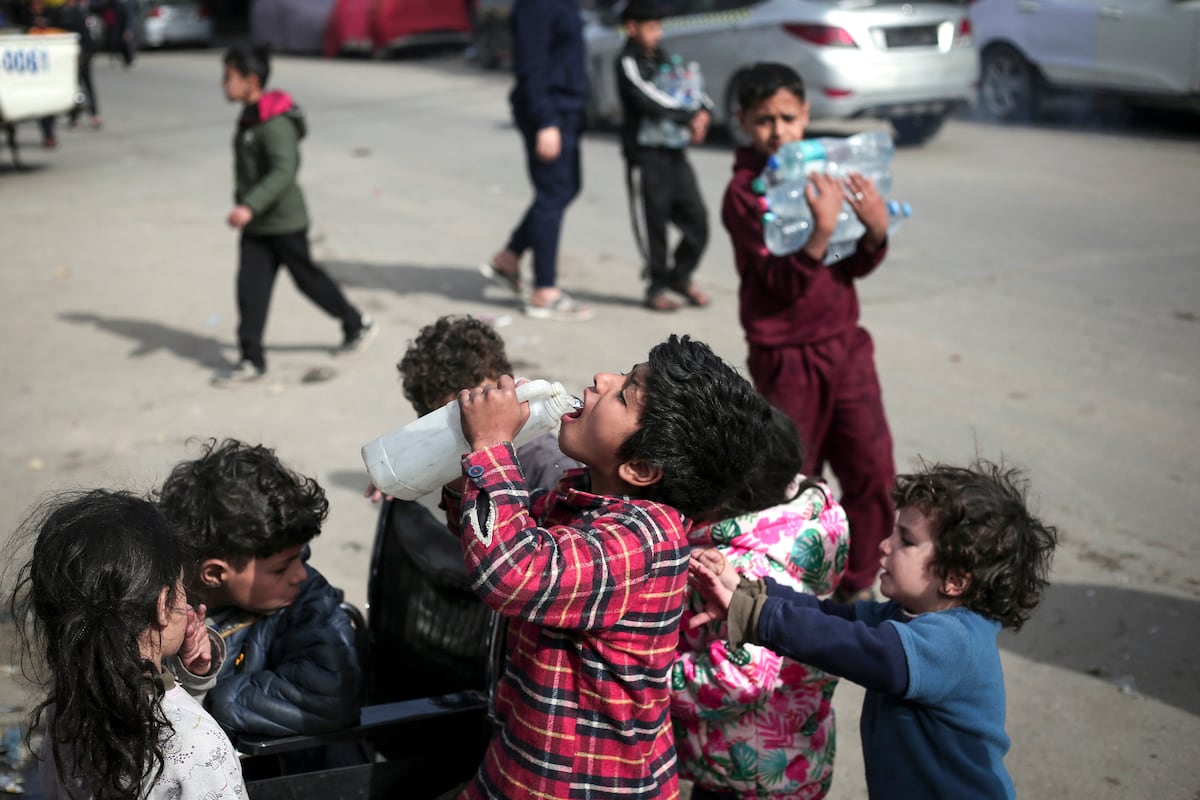Niños palestinos beben agua en Rafah, en el sur de la Franja de Gaza, en medio de las batallas en curso entre Israel y el movimiento palestino Hamás. (Foto de AFP)