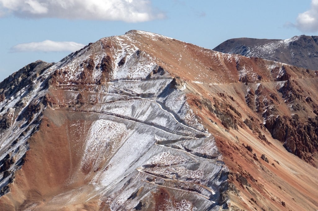 Esta imagen muestra los picos nevados de la cordillera de los Andes con una carretera construida para la exploración minera en Calingasta, provincia de San Juan, Argentina, el 21 de abril de 2026. (Foto de Luis ROBAYO / AFP)