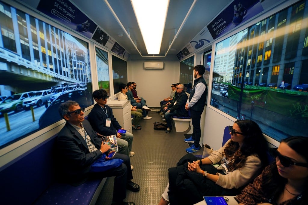 Los asistentes participan en una demostración de la compañía sueca Ericsson sobre dispositivos de realidad aumentada utilizados en los desplazamientos, en el MWC (Mobile World Congress), la feria de telefonía móvil más grande del mundo, en Barcelona, el 4 de marzo de 2025. (Foto Manaure QUINTERO / AFP)