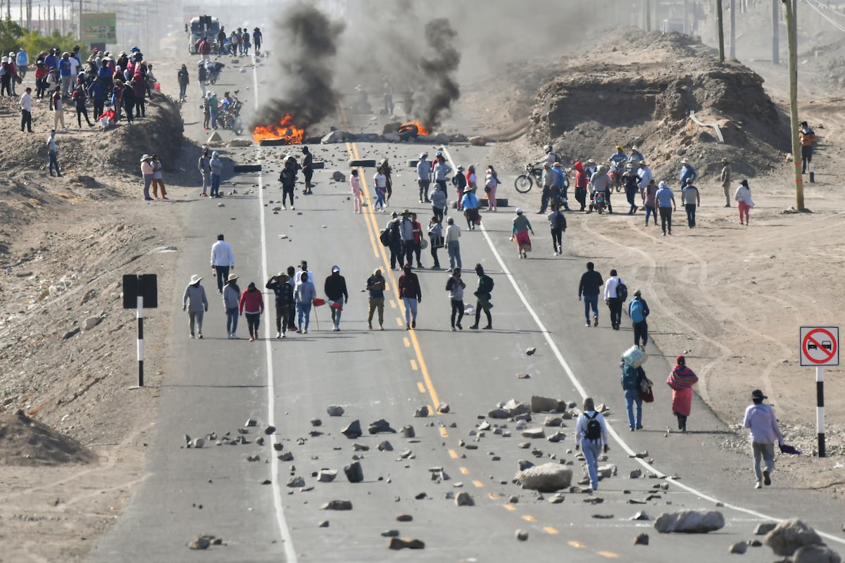Los manifestantes realizan un bloqueo en la carretera Panamericana en La Joya para exigir la renuncia de la presidenta peruana Dina Boluarte en Arequipa, Perú el 12 de enero de 2023. - Grupos de izquierda anunciaron movilizaciones en Lima este jueves para exigir la renuncia de la presidenta Dina Boluarte y elecciones anticipadas, como parte de las protestas que dejaron al menos 42 muertos en poco más de un mes, con importantes focos en zonas andinas como Cusco, meca del turismo cuyo aeropuerto cerró por seguridad. (Foto de Diego Ramos / AFP)