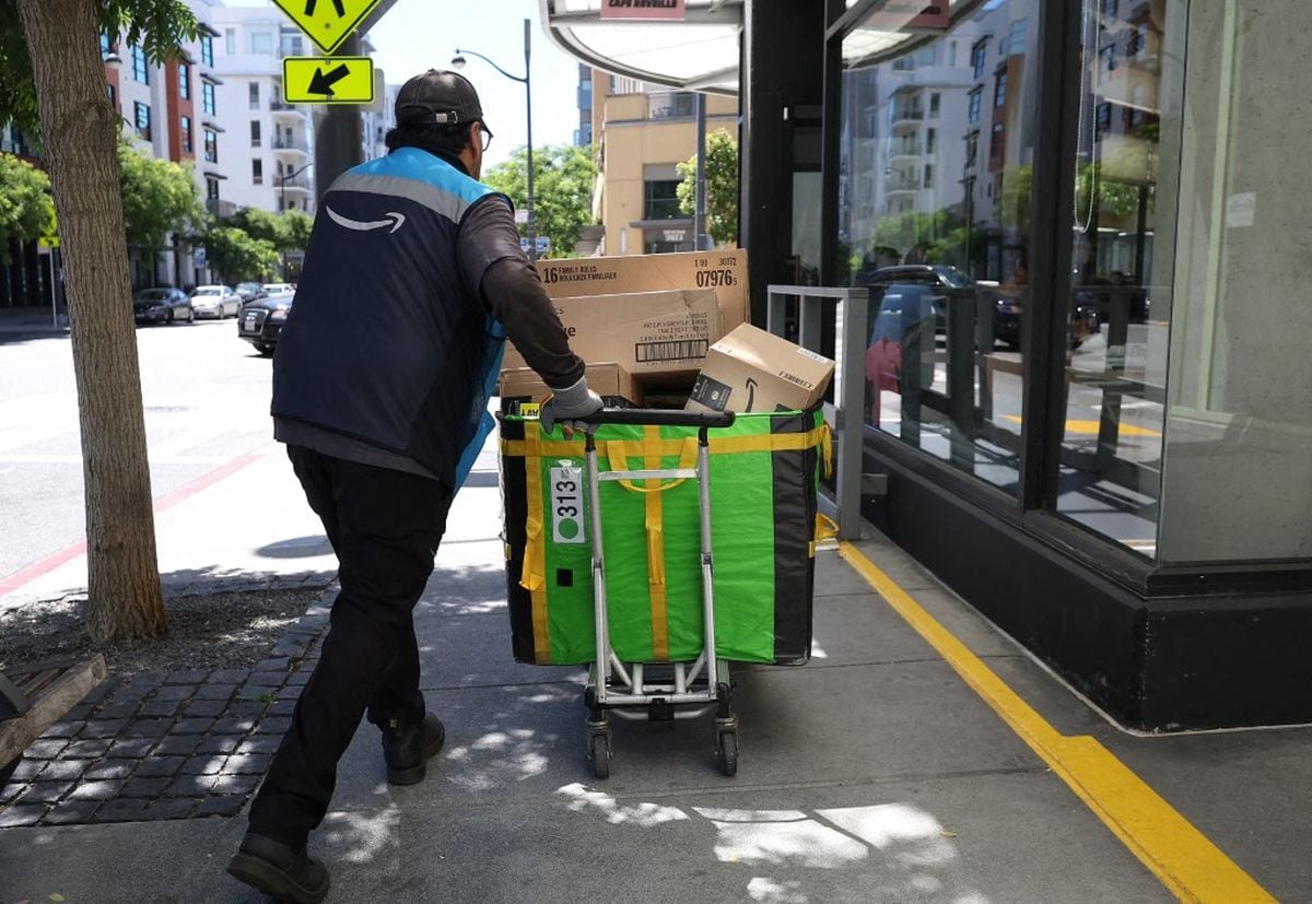 Amazon da aumento de US$1 por hora y estrena descuentos de hasta 20% en Whole Foods. En la imagen, un repartidor desplaza un carro cargado de paquetes el 16 de julio de 2024 en San Francisco, California (Foto: Justin Sullivan/Getty Images/AFP)