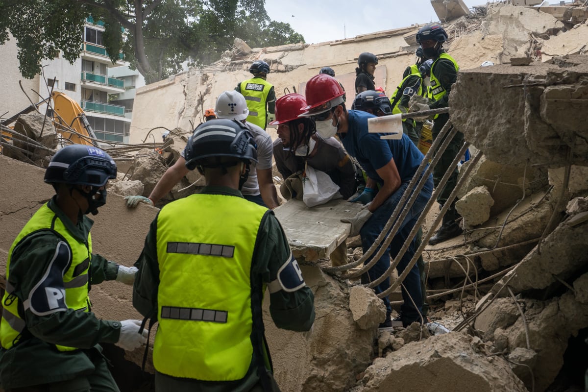 Voluntarios e integrantes de la Policía Militar de Venezuela realizan labores de remoción de escombros y rescate, en el municipio Chacao en Caracas, Venezuela, el 25 de junio de 2026. (Boris Vergara / EFE)