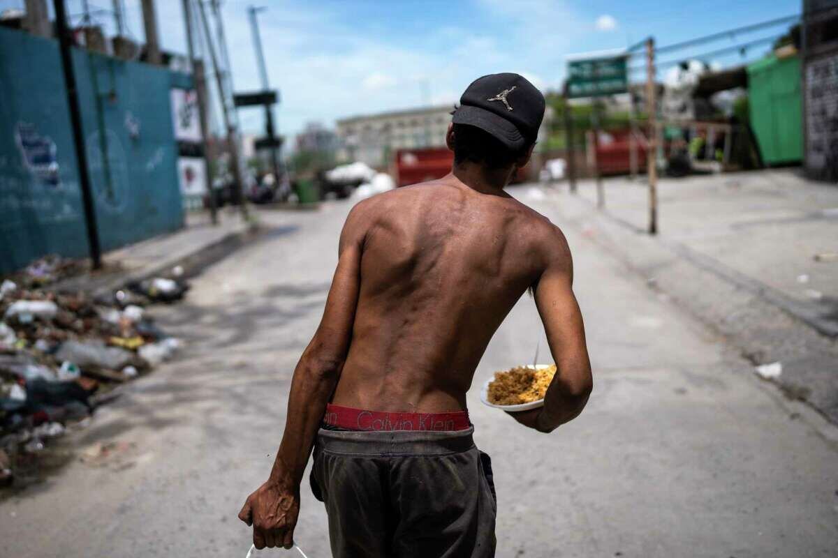 Nicolás Gonzáles camina con un plato de comida a la salida de la Casa Comunitaria del Fondo en el barrio Padre Carlos Múgica de Buenos Aires, Argentina, el miércoles 13 de de diciembre de 2023. El gobierno argentino eliminó subsidios al transporte y energía y devaluó el peso a más de la mitad, de 400 a 800 pesos por dólar, como parte de las medidas de ajuste que el nuevo presidente, Javier Milei, defiende ante las urgencias económicas del país. (AP Foto/Rodrigo Abd)