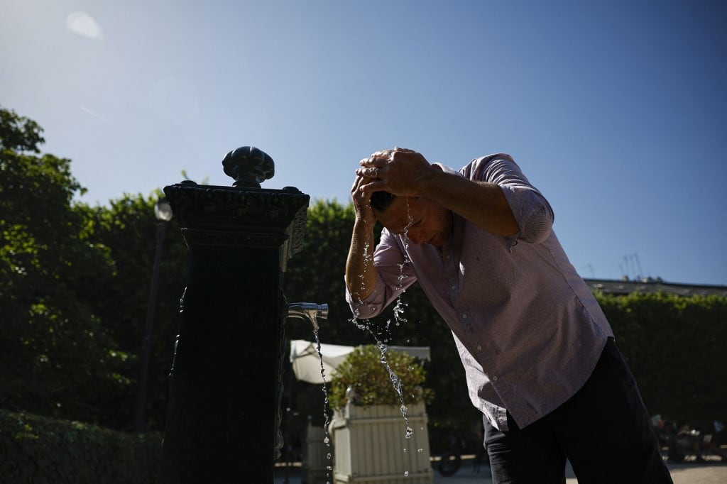 Un hombre se refresca echándose agua de una fuente en el pelo en el Jardín del Palais Royal, en el centro de París, el 26 de mayo de 2026, mientras una ola de calor azota Francia. Europa occidental se enfrentó el martes a otro día de temperaturas récord, ya que una ola de calor elevó el termómetro muy por encima de los niveles normales para mayo. Una denominada "cúpula de calor", una masa de aire cálido procedente del norte de África atrapada bajo un sistema de alta presión sobre Europa occidental, es la causante de este calor que normalmente no se ve hasta pleno verano. (Foto de SIMON WOHLFAHRT / AFP)