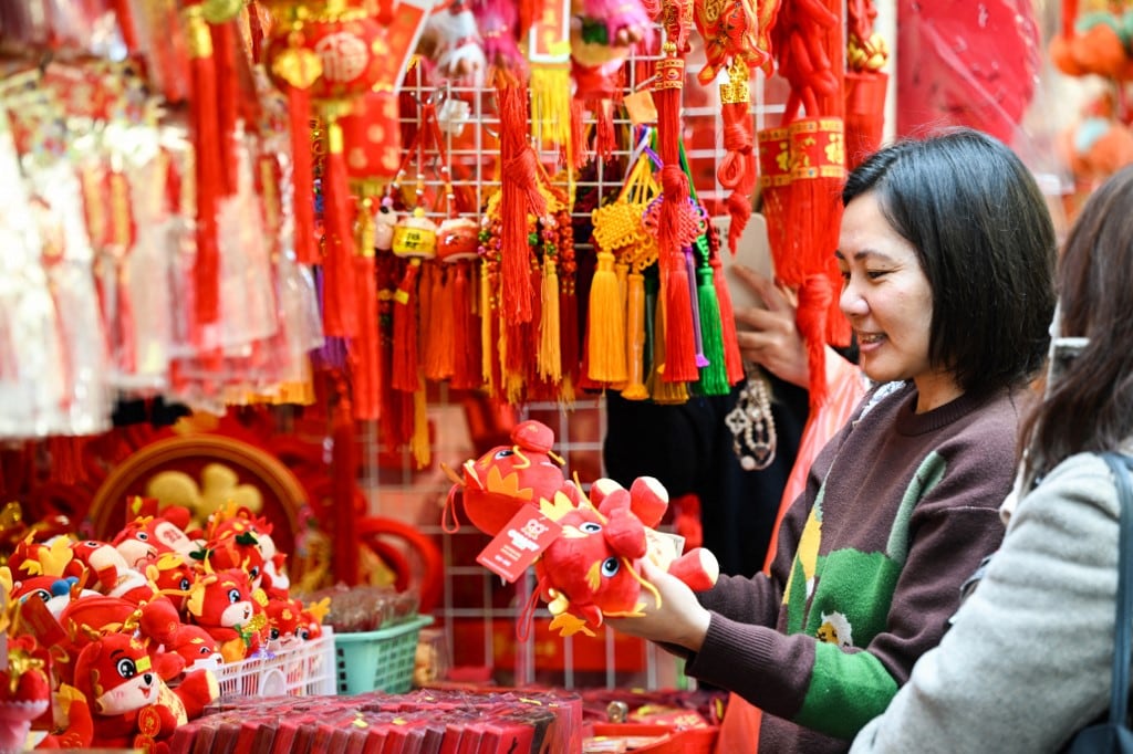 Un cliente mira juguetes de dragones antes del Año Nuevo Lunar en Hong Kong el 30 de enero de 2024 para el próximo Año del Dragón. (Foto de Peter PARQUES / AFP)