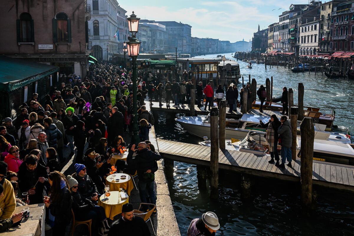 (ARCHIVOS) Visitantes y turistas se reúnen junto al Gran Canal durante el carnaval de Venecia el 11 de febrero de 2023. (Foto de Miguel MEDINA/AFP)