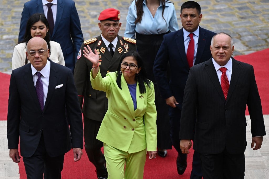 Venezuela's interim President Delcy Rodriguez (C) waves next to her brother, President of the National Assembly Jorge Rodriguez (L), and Minister of the Popular Power for Interior Diosdado Cabello, as she arrives to a presidential address to Parliament at the National Assembly in Caracas on January 15, 2026. US President Donald Trump is scheduled to meet Thursday with Venezuelan opposition leader Maria Corina Machado, whose pro-democracy movement he has sidelined since toppling her country's leader, and whose Nobel Peace Prize he openly envies. (Photo by Federico PARRA / AFP)