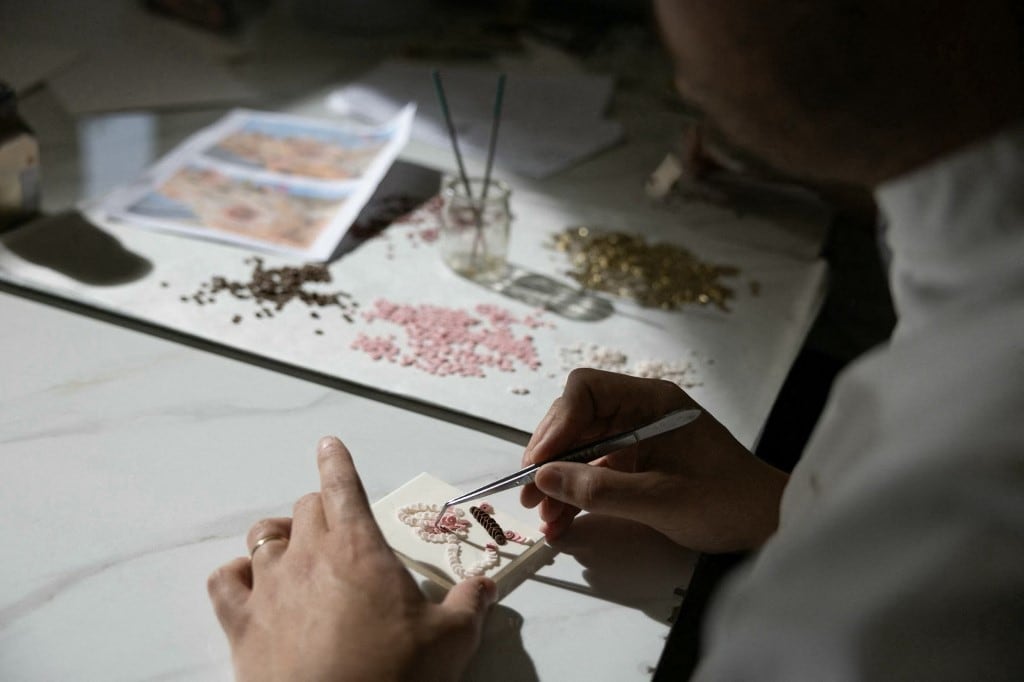 El pastelero francés Bastien Blanc-Tailleur crea decoraciones para un pastel de bodas en su estudio de Saint-Remy-les-Chevreuse, al suroeste de París, el 10 de abril de 2026. (Foto de Thomas SAMSON / AFP)