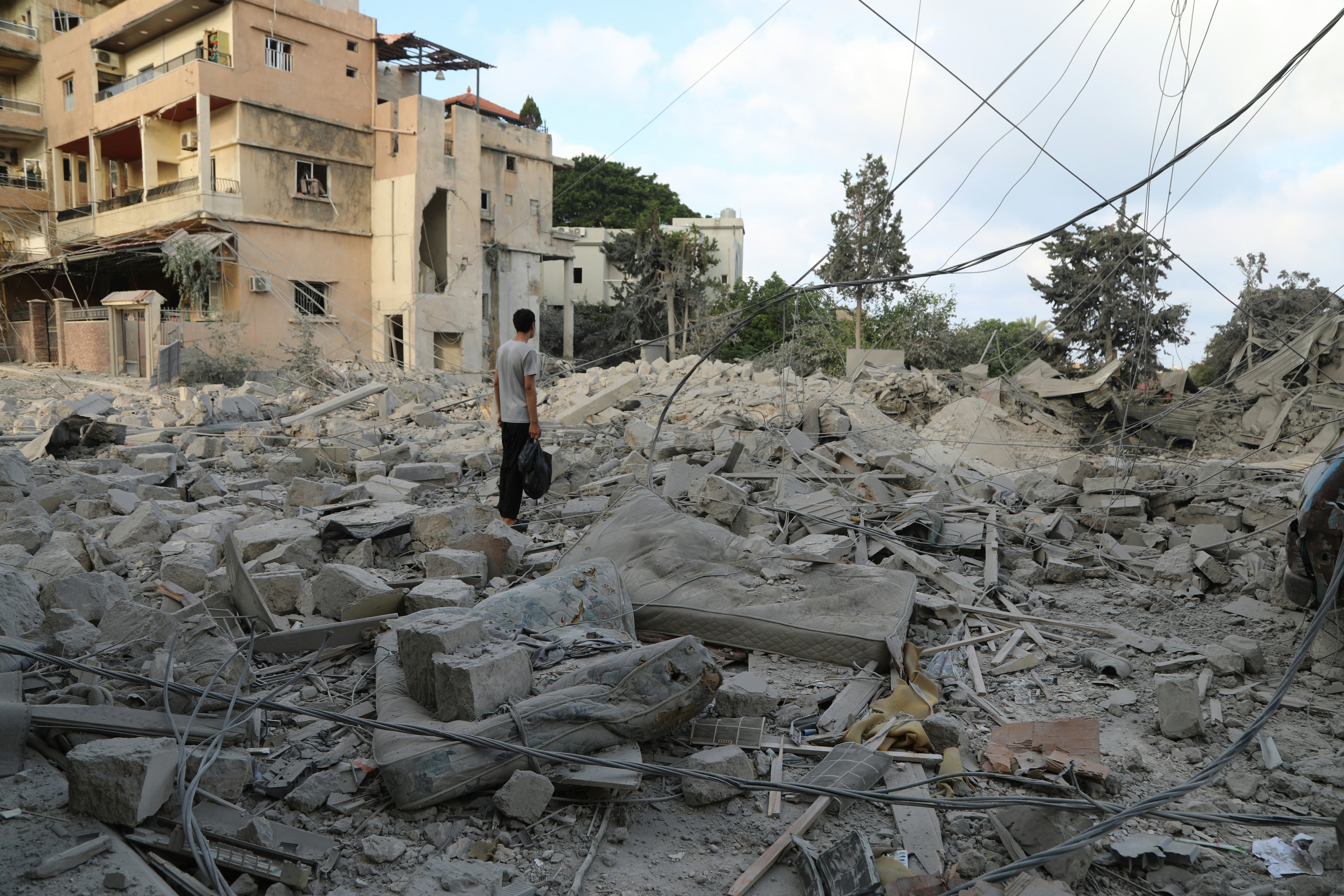 A man stands amid debris following Israeli airstrikes that hit the previous day, near the archaeological site of the Roman hippodrome in the southern Lebanese city of Tyre on June 8, 2026. On June 7, the Israeli military issued an evacuation warning for most of Tyre and its surroundings. The coastal city shelters thousands of displaced people and has been heavily bombed since the fighting began. (Photo by KAWNAT HAJU / AFP) /