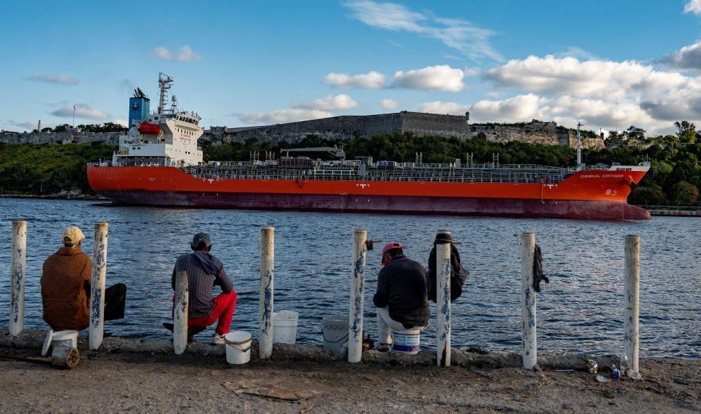 Un barco petrolero en la costa de La Habana y hombres pescadores viéndolo de espaldas Foto: AFP