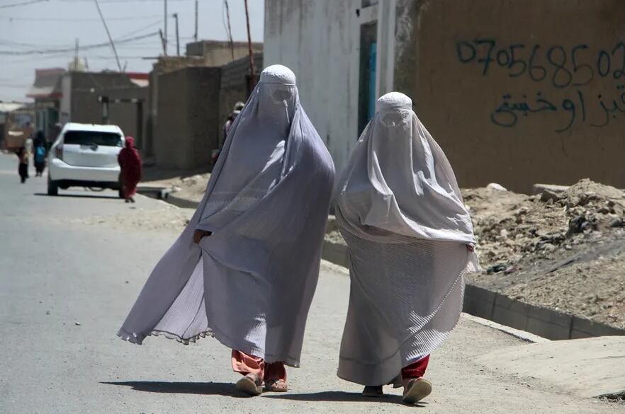 Mujeres afganas vestidas con burka caminan por una carretera en Kandahar. EFE/EPA/Qudratullah Razwan
