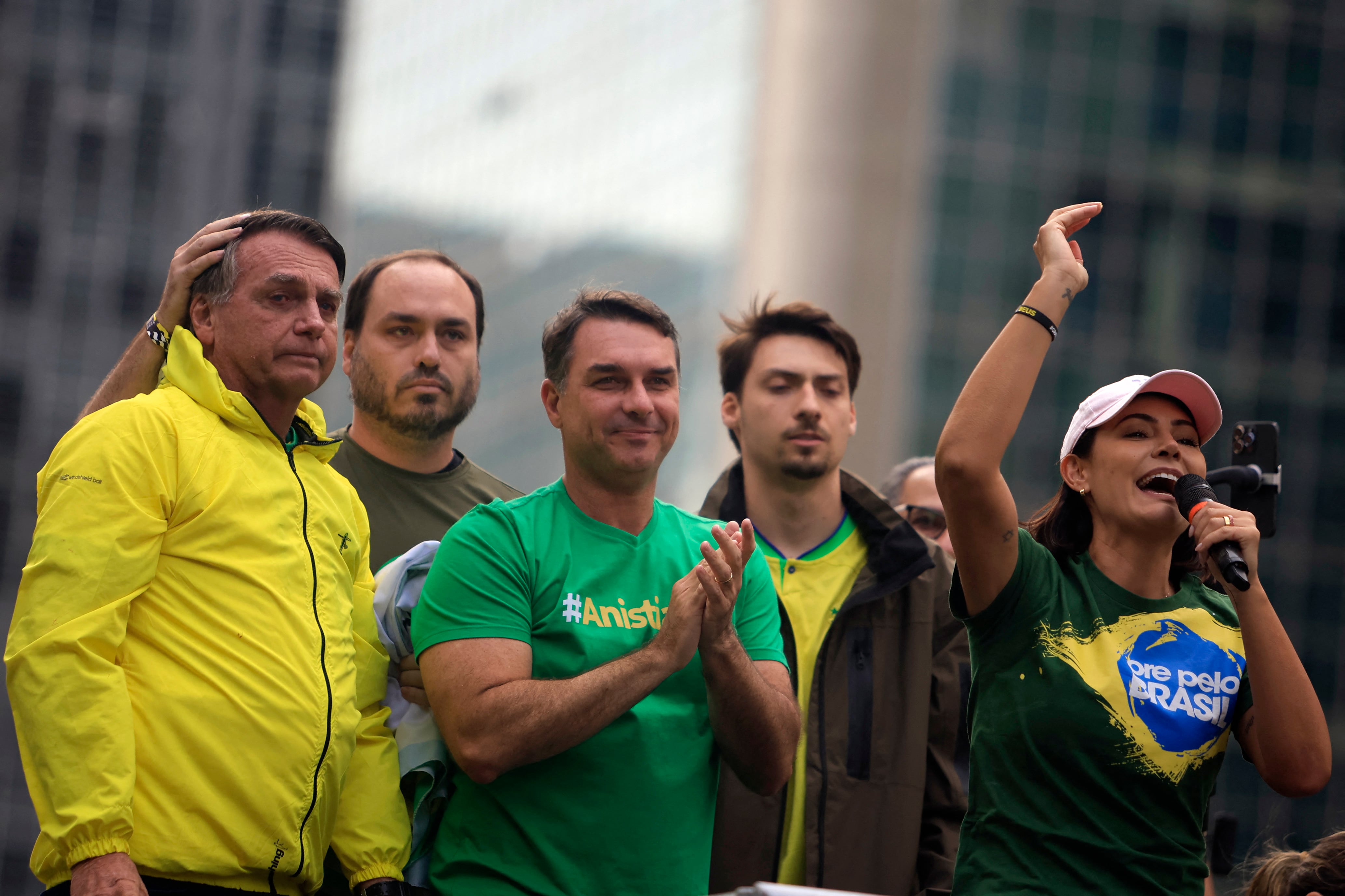 Michelle Bolsonaro habla junto a su esposo, el expresidente de Brasil Jair Bolsonaro (I), y sus hijos Carlos (2-I), Flavio (C) y Renan durante un mitin en la Avenida Paulista en São Paulo, Brasil, el 6 de abril de 2025. (Foto de Miguel SCHINCARIOL / AFP).
