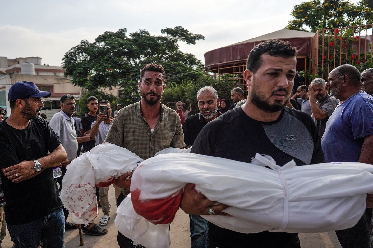 Dolientes llevan cuerpos a un cementerio en Khuzaa, en el sur de la Franja de Gaza, tras un ataque israelí nocturno que afectó su casa en Bani Suheila, el 21 de julio de 2024. (Foto de Bashar TALEB / AFP)