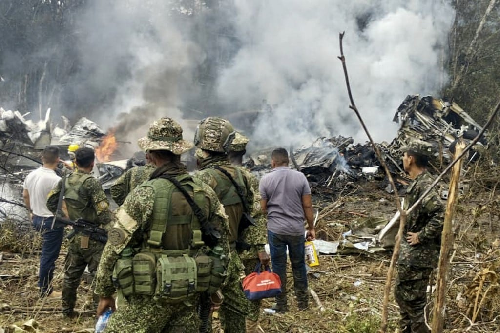 Esta captura de pantalla muestra a soldados y rescatistas cerca de un avión Hércules de la Fuerza Aérea que emite una densa humareda tras estrellarse durante el despegue en Puerto Leguizamo, Colombia, cerca de la frontera sur con Ecuador, el 23 de marzo de 2026. El ejército colombiano informó el 23 de marzo que se creía que unos 80 soldados habían muerto tras el accidente de un avión de transporte en el sur del país. (Foto de Daniel Ortiz / AFP)