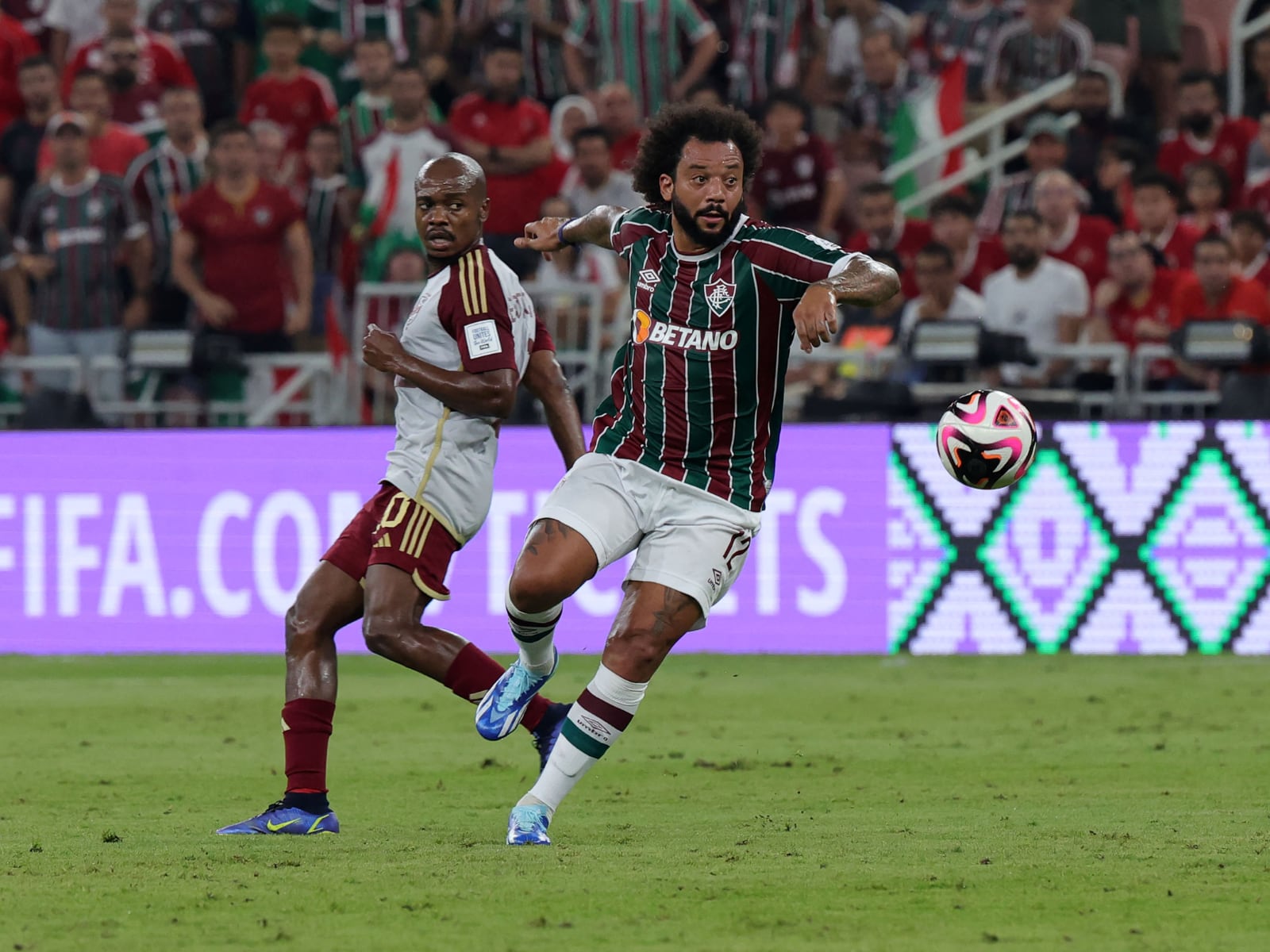El defensa brasileño del Fluminense #12 Marcelo disputa el balón con el delantero sudafricano del Ahly #10 Percy Tau durante el partido de fútbol de semifinales de la Copa Mundial de Clubes de la FIFA entre el Fluminense brasileño y el Al-Ahly egipcio en el King Abdullah Sport City de Jeddah el 18 de diciembre de 2023. | Crédito: Giuseppe Cacace / AFP