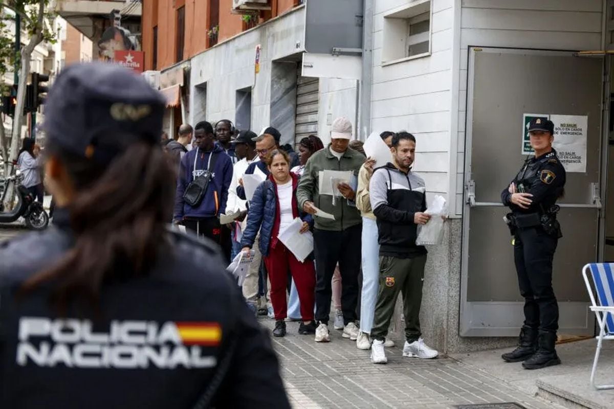 Decenas de personas hacen fila a las puertas de la Oficiana de Atención a la Ciudadanía en Elche, para presentar documentación dentro de su proceso de regularización. Foto: EFE/Pablo Miranzo