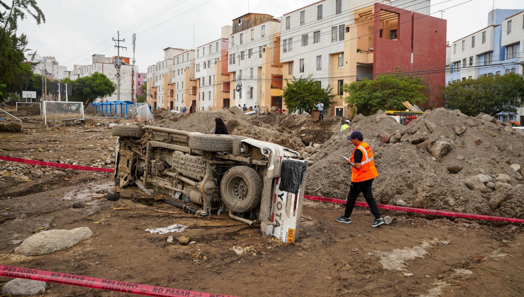 Las intensas lluvias han provocado deslizamiento, huaicos e inundaciones en Perú. En la imagen, un hombre pasa junto a una camioneta volcada tras las fuertes lluvias en la ciudad de Arequipa, sur de Perú, el 25 de febrero de 2026 (Foto: Diego Ramos / AFP)