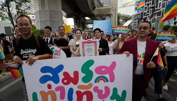 Participantes sostienen carteles que celebran el matrimonio igualitario en Bangkok, Tailandia (AP Foto/Sakchai Lalit)