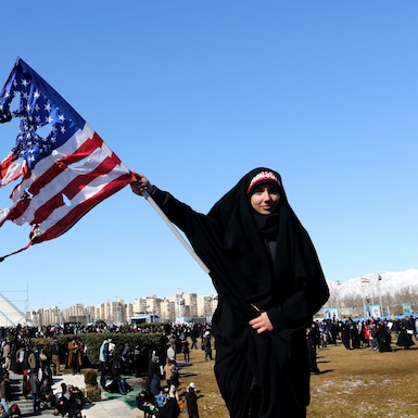 Una iraní ondea una bandera estadounidense quemada durante las conmemoraciones de los 41 años de la Revolución Islámica el 11 de febrero del 2020. (Foto por ATTA KENARE / AFP).