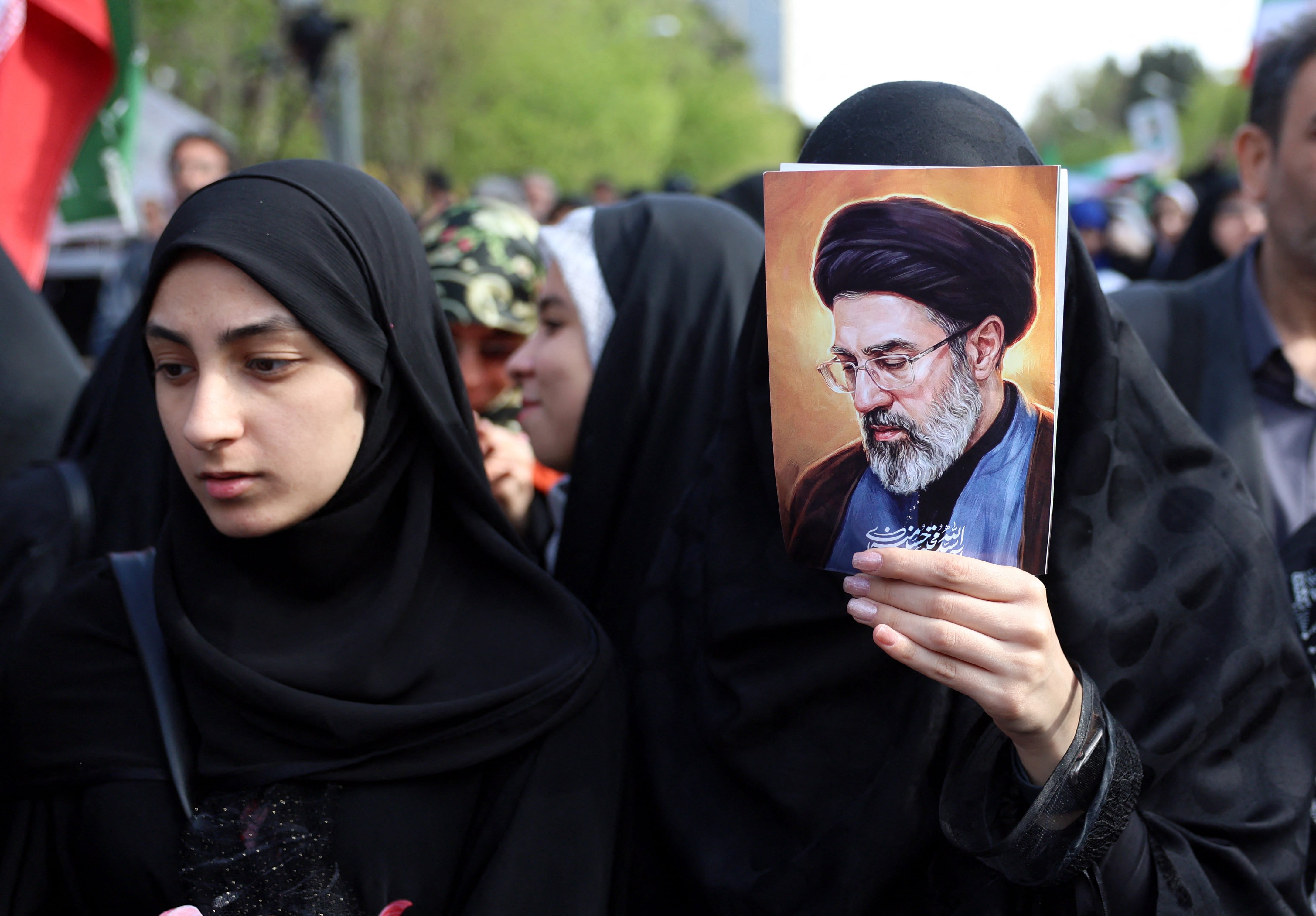 Ciudadanos iraníes, uno de ellos portando la imagen del líder supremo Mojtaba Khamenei, se congregan durante un acto conmemorativo, 40 días después del mortal ataque a una escuela infantil en la ciudad sureña de Minab. (Foto de AFP).
