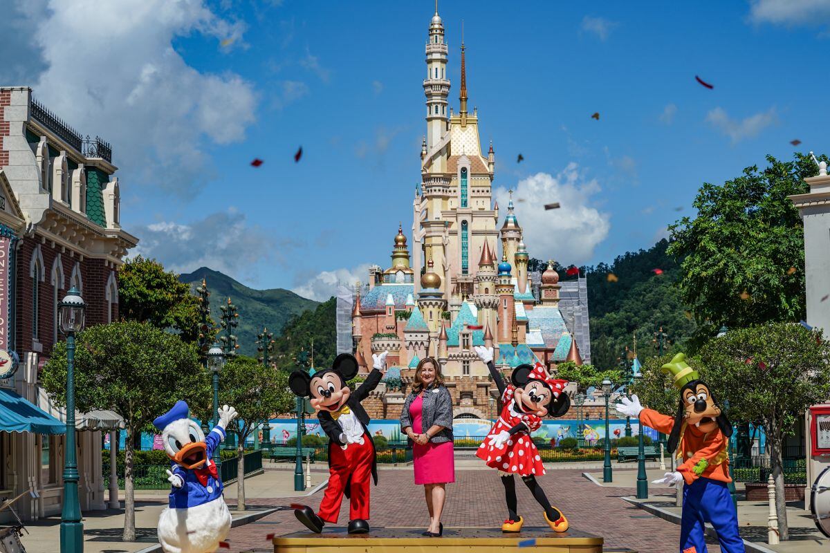 Stephanie Young, directora general de Hong Kong Disneyland Resort, en el centro, sube al escenario con actores vestidos como el Pato Donald, desde la izquierda, Mickey Mouse, Minnie Mouse y Goofy en el Disneyland Resort de Walt Disney Co. en Hong Kong, China, el jueves 18 de junio de 2020.