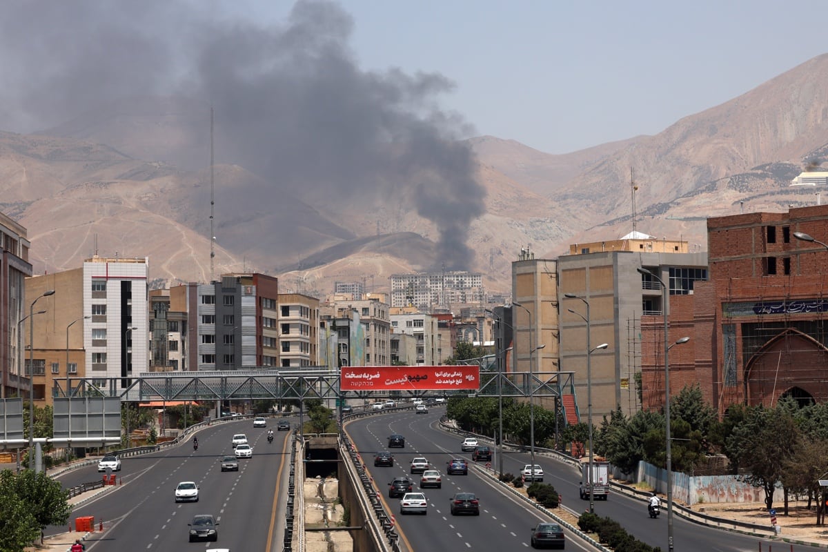 Automóviles circulan por una autopista mientras se eleva humo en el fondo desde una refinería de petróleo, al noroeste de Teherán, Irán, el 16 de junio de 2025. (Foto de EFE/EPA/ABEDIN TAHERKENAREH)