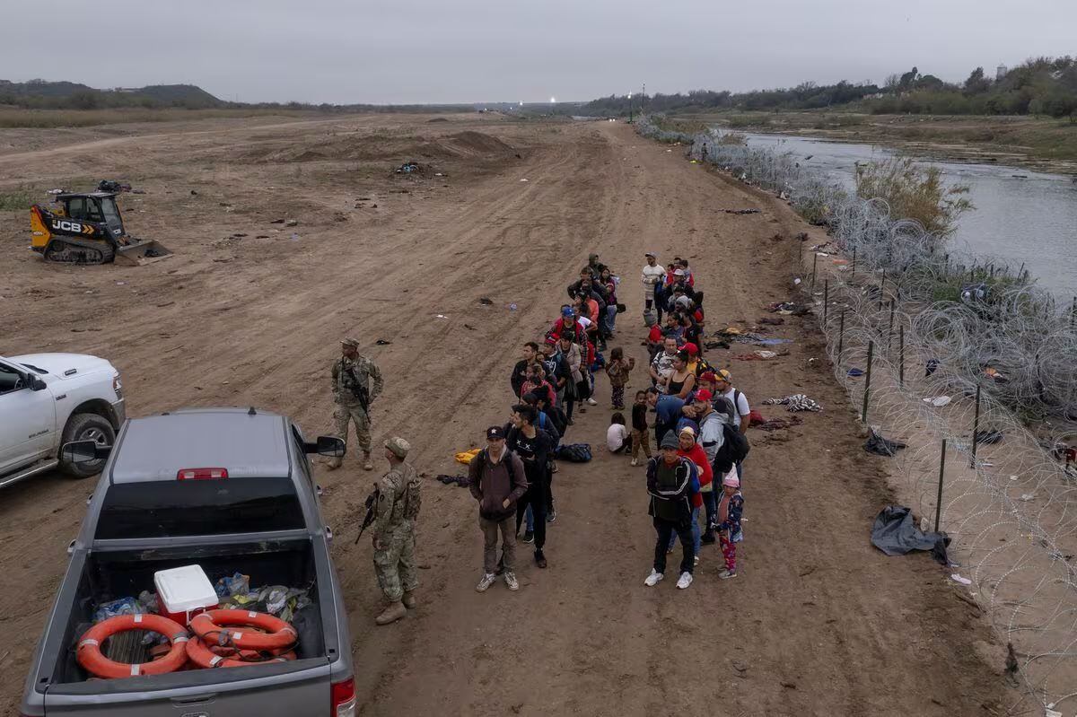 Migrantes esperan para ser procesados, luego de cruzar el río Bravo, en Eagle Pass (Texas).
CHENEY ORR (REUTERS)