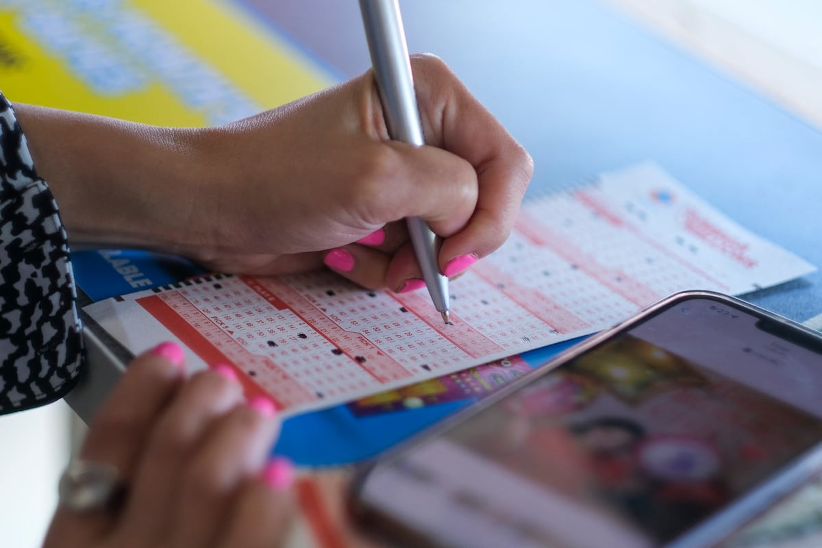 Una ciudadana llenando los números de sus boletos de Mega Millions en California (Foto: AFP)