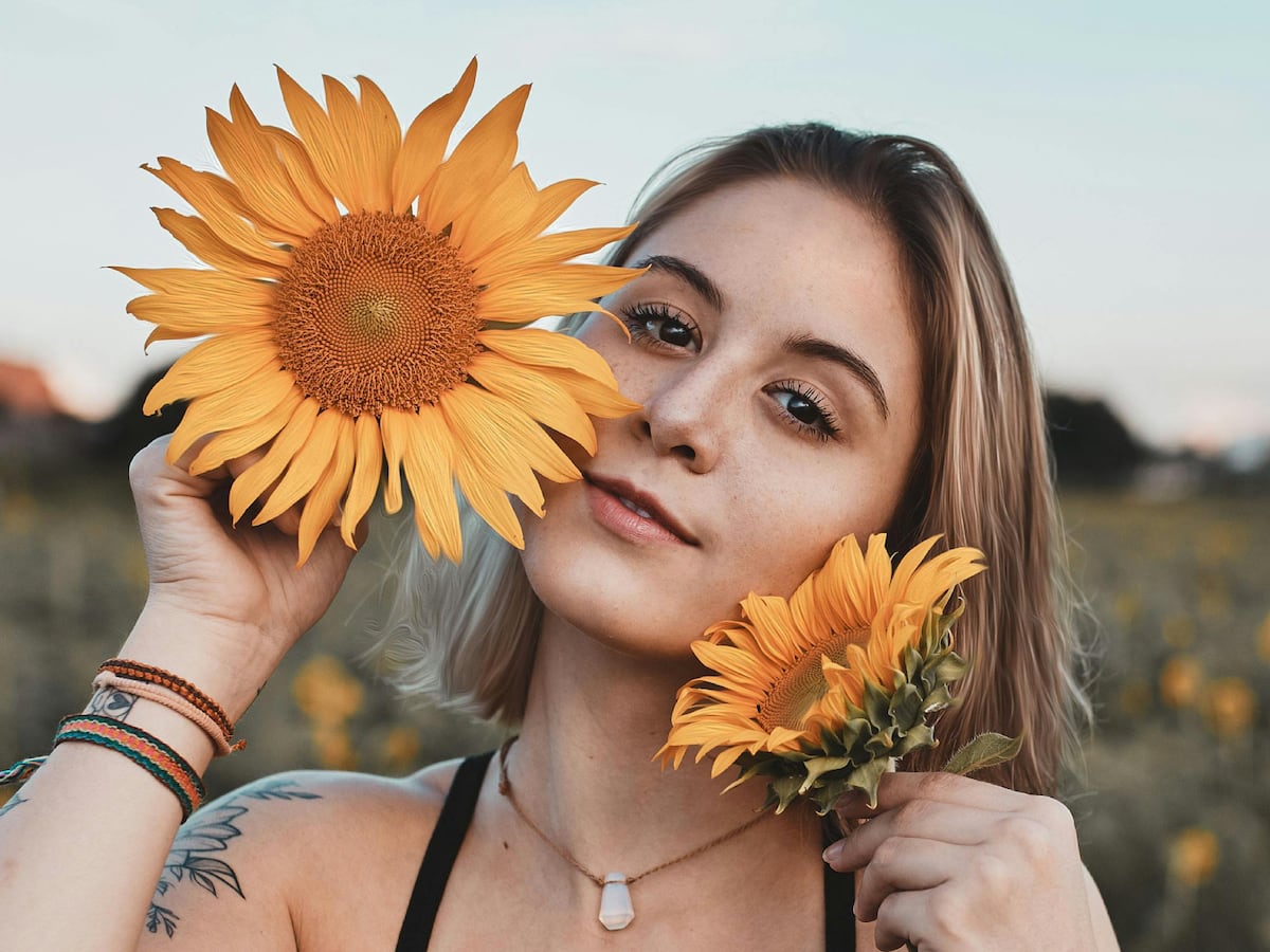 Una joven sujetando unos girasoles que podrían guardar un gran significado (Foto: Pexels)