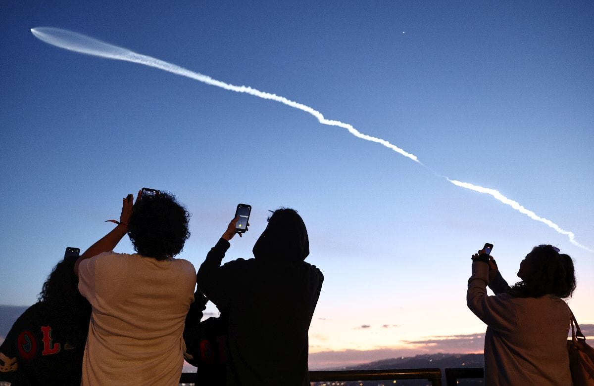Personas observan un cohete SpaceX Falcon 9 que transporta 22 satélites de internet Starlink al espacio después de su lanzamiento desde la Base de la Fuerza Espacial Vandenberg en Los Ángeles en 2024. Fotógrafo: Mario Tama/Getty Images