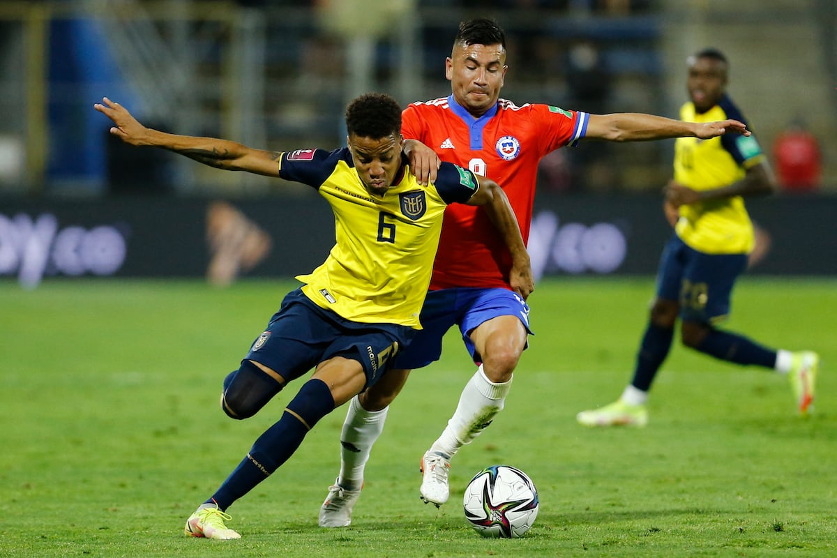 Byron Castillo (L) de Ecuador y Jean Meneses de Chile compiten por el balón durante su partido de fútbol clasificatorio sudamericano para la Copa Mundial de la FIFA Qatar 2022 en el estadio San Carlos de Apoquindo en Santiago, el 16 de noviembre de 2021. (Foto de Marcelo HERNANDEZ / PISCINA / AFP)