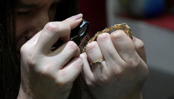 Una tasadora examina una pulsera de oro en un comercio de compra-venta de joyas en Buenos Aires |  Juan Mabromata / AFP