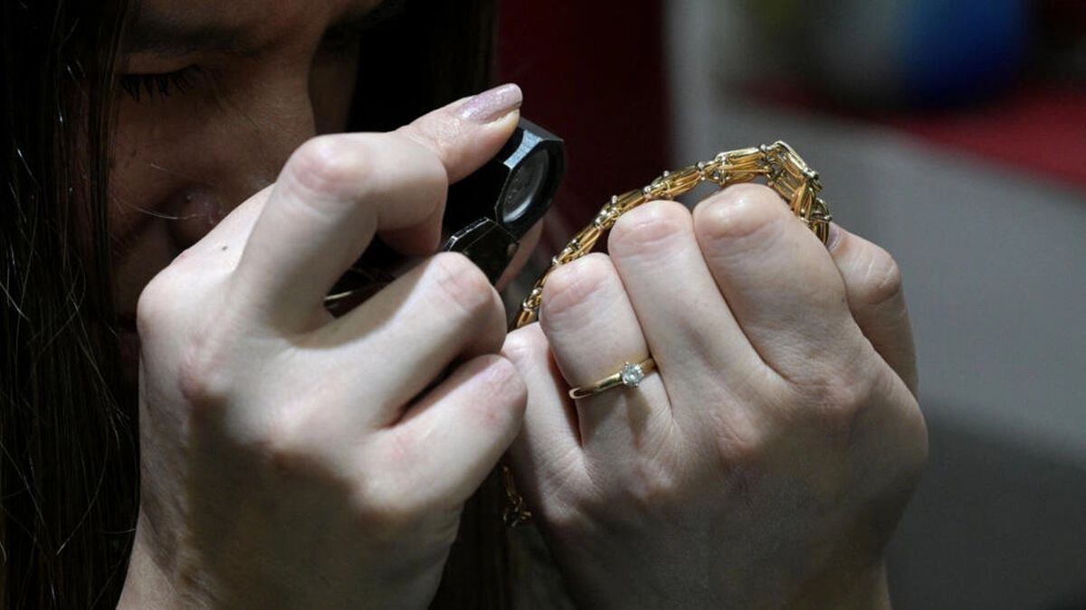 Una tasadora examina una pulsera de oro en un comercio de compra-venta de joyas en Buenos Aires | Juan Mabromata / AFP