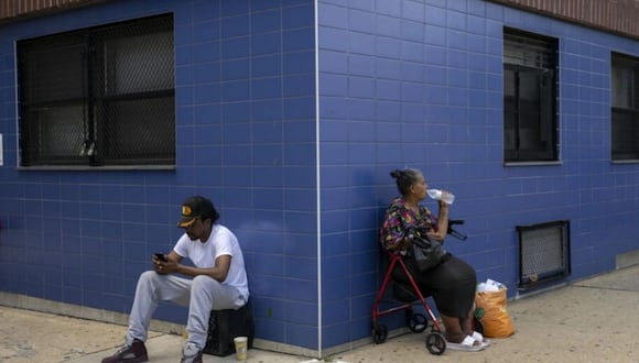 Dos personas sentadas ante un centro para mayores en el distrito de Bronx en Nueva York. ANGELA WEISS / AFP