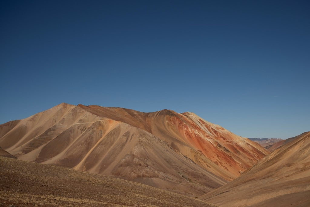 Esta imagen muestra las cumbres de la cordillera de los Andes con una carretera construida para la exploración minera en Calingasta, provincia de San Juan, Argentina, el 22 de abril de 2026. "La minería se extenderá por toda la cordillera, generando cientos de miles de empleos", predijo el presidente argentino Javier Milei en marzo. Semanas después, promulgó una reforma de la ley de protección de glaciares que permitirá a las provincias abrir nuevas áreas a la minería. Grupos ambientalistas impugnaron la medida ante los tribunales, argumentando que amenaza el acceso al agua. (Foto de Luis ROBAYO / AFP)