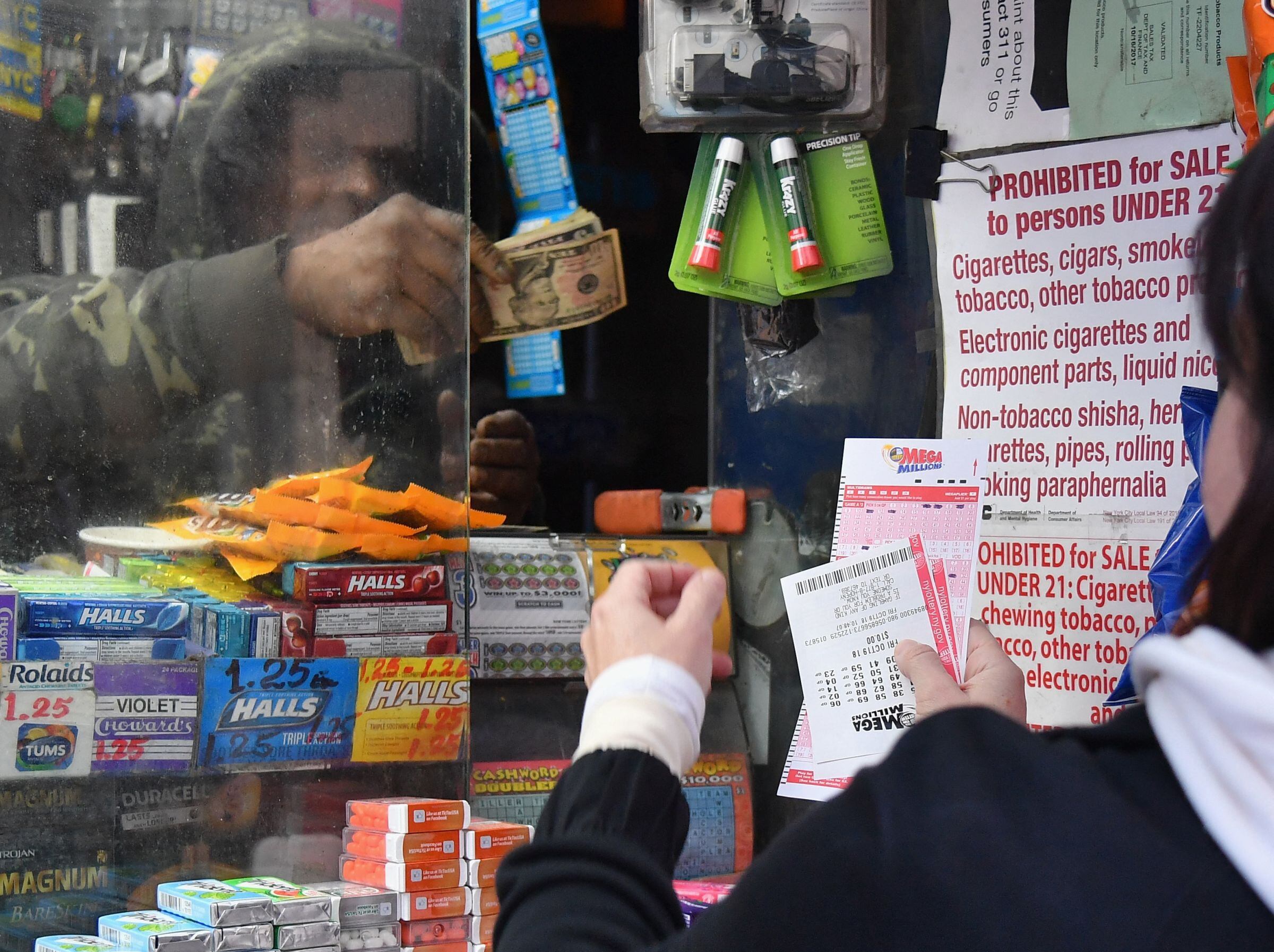 El momento en que una mujer compra un boleto de Mega Millions. (Foto: Angela Weiss / AFP)