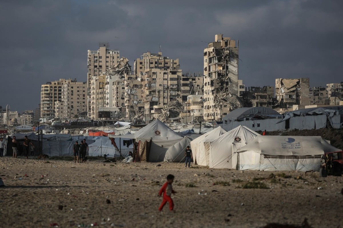 Un niño palestino camina cerca de un campamento para desplazados en la playa de la ciudad de Gaza, el 3 de julio de 2026. (EYAD BABA / AFP)