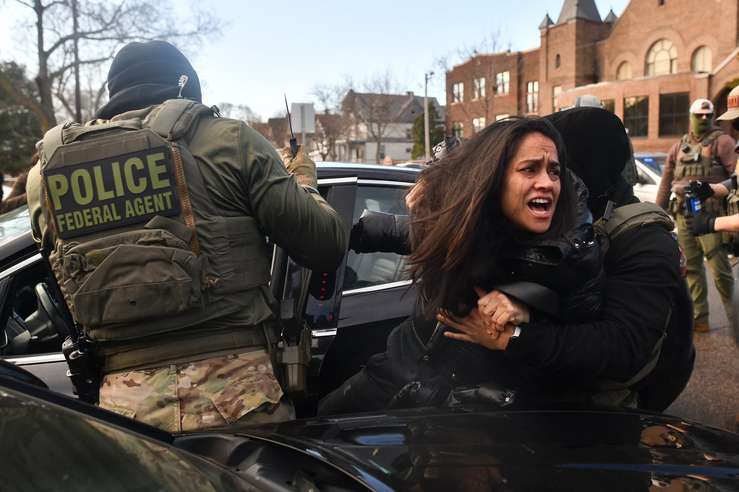 El Servicio de Inmigración y Control de Aduanas (ICE) y otros agentes federales retiran a una mujer de su vehículo en Minneapolis, Minnesota. (Foto de Octavio JONES / AFP).